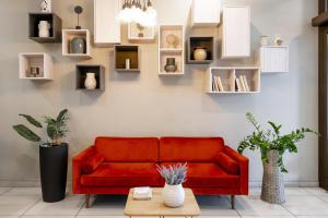 a living room with a red couch and shelves at B&B Hotel Milano-Monza in Monza