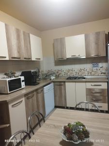 eine leere Küche mit einem Tisch und einer Mikrowelle in der Unterkunft Casa Bran in Buşteni