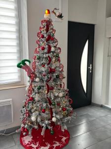 Un árbol de Navidad decorado con adornos rojos y blancos. en Chez Aurore, en Port-de-Bouc 4 fotos más