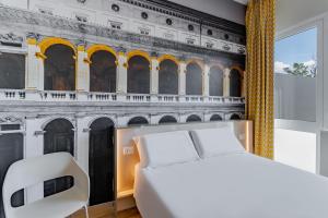 1 dormitorio con un mural de un edificio en B&B Hotel Roma Pietralata Tiburtina, en Roma