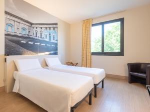 San Giorgio Di MantovaにあるB&B HOTEL Mantovaの窓のある部屋にベッドが2つある