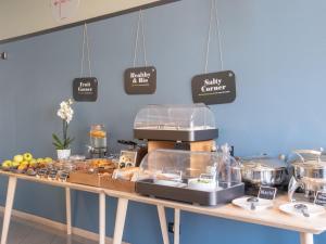 San Giorgio Di MantovaにあるB&B HOTEL Mantovaのテーブルの上に食べ物が置かれたパン屋のカウンター