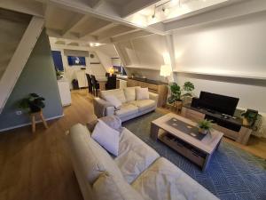 Una sala de estar con dos sofás y un televisor. en Sequoia Duo 2 chalets voisins, familles,amis,détente, en Durbuy