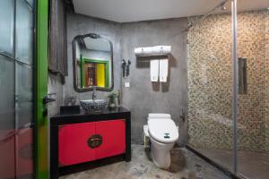 a bathroom with a toilet and a sink and a mirror at Hotel Cote Cour Beijing in Beijing