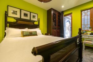 a bedroom with a large bed with green walls at Hotel Cote Cour Beijing in Beijing