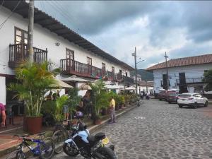 eine Straße in einer Stadt mit geparkten Autos und Gebäuden in der Unterkunft Casa Doña Blanca in Guaduas
