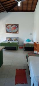 Dos camas en una habitación con esteras rojas en el suelo. en Vila Feliz Arraial, en Arraial d'Ajuda 27 fotos más