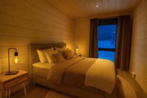 Un dormitorio con una cama grande y una ventana. en Palojärven Lomakeskus, en Sonka