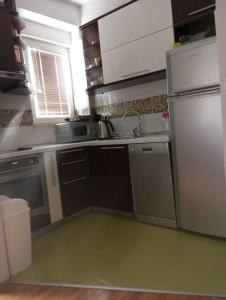 a small kitchen with a refrigerator and a sink at SKY Apartments in Ohrid