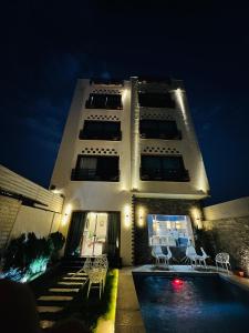卢克索Farida Palace Hotel的一座建筑,在晚上前方有一个游泳池