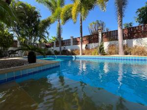 a swimming pool with palm trees in front of a house at Project 17 B&B in Hua Hin