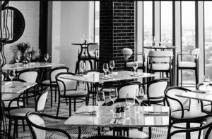 ein Restaurant mit Tischen und Stühlen und Fenstern in der Unterkunft Seaview stay at Cinnamon Life Residence - City of Dreams in Colombo + 10 Fotos