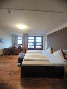 een kamer met vier bedden en een bank bij Hotel an der Hörn in Kiel