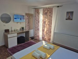 霍雷祖Casa ANDRADA的一间卧室，里面有一张床、一张桌子和一台电视。