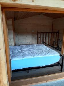 a bed in a room with a wooden wall at La Roselière cottage at Lake Laffrey with parking in Laffrey +15 photos
