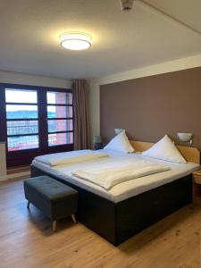 Un dormitorio con una cama grande y una ventana. en Hotel an der Hörn, en Kiel