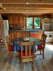 a kitchen with a table and chairs in a cabin at La Roselière cottage at Lake Laffrey with parking in Laffrey