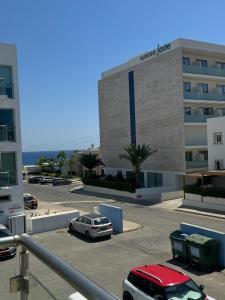 a building with a car parked in a parking lot at A Home at Coralli - Protaras Beach Apartment, 30 m from beach in Protaras