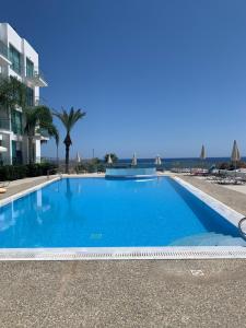 a large blue swimming pool in front of a building at A Home at Coralli - Protaras Beach Apartment, 30 m from beach in Protaras