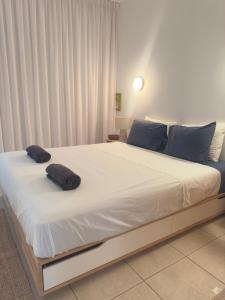 a bedroom with a large bed with two pillows on it at A Home at Coralli - Protaras Beach Apartment, 30 m from beach in Protaras