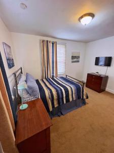 una camera da letto con un letto, un tavolo e una televisione di Natvy Alpha Suite - 3 Bedroom a Munhall