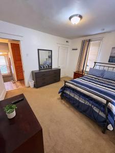 una camera da letto con un letto, un tavolo e uno specchio di Natvy Alpha Suite - 3 Bedroom a Munhall Altre 17 foto