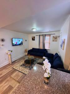 un soggiorno con un divano blu e una TV a schermo piatto di Natvy Alpha Suite - 3 Bedroom a Munhall