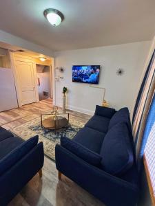 un soggiorno con un divano blu e una TV di Natvy Alpha Suite - 3 Bedroom a Munhall