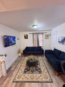 een woonkamer met twee blauwe banken en een tapijt bij Natvy Alpha Suite - 3 Bedroom in Munhall