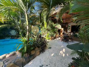 a resort with a swimming pool and palm trees at Cahuita Vibe in Cahuita