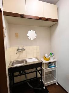 a small kitchen with a sink and a mirror at cozy guesthouse in Osaka +22 photos