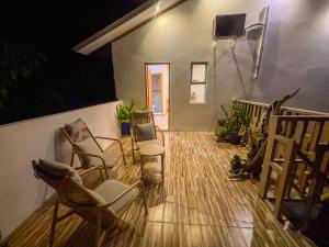 een woonkamer met stoelen en een houten vloer bij Eco Palm Maldives in Mathiveri