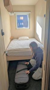 a woman kneeling down next to a bed in a room at Sho inn MINIMAL HOTEL 小樽駅から無料送迎あり in Otaru +35 photos