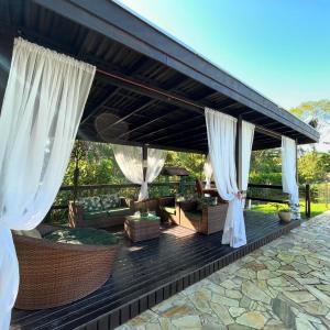 un patio esterno con tende bianche e divani di Recanto Carvalho - Suíte 2 a Itapoa