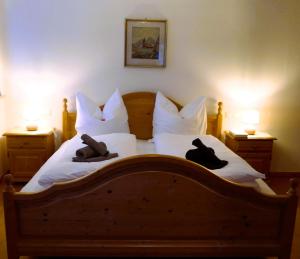 a bedroom with a wooden bed with two hats on it at Bodenschneidsuiten Das Gschwandler in Tegernsee
