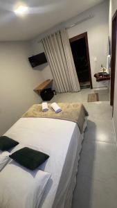 a bedroom with a large bed with two towels on it at Pousada Na Serra Ubajara in Ubajara