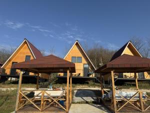 a group of cottages with tables and umbrellas at Aroma of the forest in Martvili