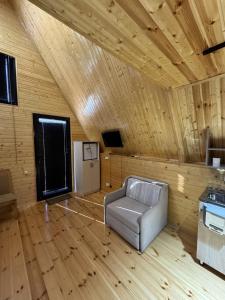 a living room with a chair in a wooden room at Aroma of the forest in Martvili