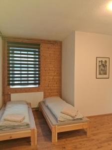 two beds in a room with a window at U Tomáška in Malá Morávka