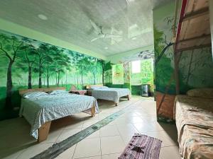ein Schlafzimmer mit zwei Betten und einem Wandgemälde mit Bäumen in der Unterkunft Cahuita Vibe in Cahuita + 42 Fotos