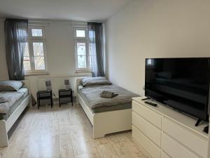 a living room with two beds and a flat screen tv at Monteurzimmer Renix Heilbronn in Brackenheim