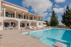 una villa con piscina e una casa di Rivazzurra Beachfront Luxury Villa a Lithakia
