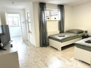 a bedroom with a bed and a television in it at Monteurzimmer Renix Heilbronn in Brackenheim