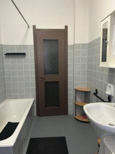 a bathroom with a tub and a sink and a door at Lake Garda in Gavardo +21 photos