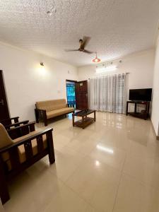 ein Wohnzimmer mit Sofa und Fernseher in der Unterkunft The Green Thumb Farm Stay in Mundakāyam + 21 Fotos