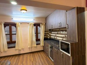 a large kitchen with wooden cabinets and a window at Hacos Nepal stay in Bhaktapur