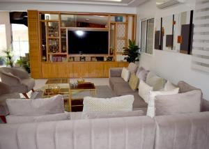 Una sala de estar con dos sofás y un televisor. en Villa Lalla Laroussa, en Kenitra