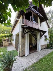 a house with a balcony and a patio at Pancsoló Rigó & Mérges Harkály Apartments in Dunapataj