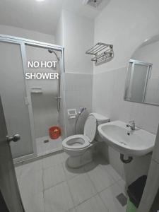 Un baño con inodoro y lavabo y ducha sin agua caliente. en Pool View Studio in Mesaverte with Free Pool & Netflix, en Cagayan de Oro
