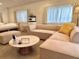 een woonkamer met een bank en een tafel bij スタイリッシュハウス博多 in Fukuoka